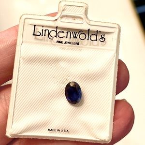 Faceted blue gemstone in jewel sleeve from fine jeweler believed to be sapphire
